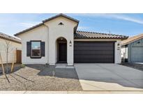 Charming single-story home with a neutral color palette and a dark brown two car garage at 7657 W Minton St, Laveen, AZ 85339