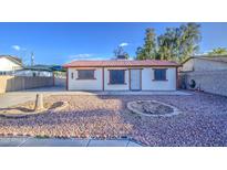 Quaint home with a well-maintained yard, featuring decorative rock and a metal roof at 10917 W Apache St, Avondale, AZ 85323