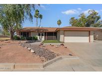 Charming single-story home with a two-car garage, mature trees, and well-kept landscaping at 11444 S 51St St, Phoenix, AZ 85044