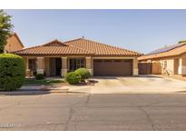 Charming single-story home featuring a two-car garage and a well-manicured front yard at 16577 W Garfield St, Goodyear, AZ 85338