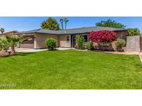 Charming brick home with a well-manicured lawn and beautiful landscaping at 1708 E Impala Ave, Mesa, AZ 85204
