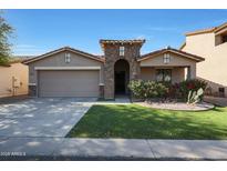 Charming single-story home featuring a well-maintained lawn and a two-car garage at 2181 E 27Th Ave, Apache Junction, AZ 85119