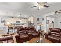 Inviting living room featuring comfortable leather seating, neutral walls, and wood-look floors at 5218 W Lydia Ln, Laveen, AZ 85339