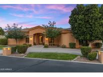 Stunning single-story home boasts meticulous landscaping and a welcoming arched entryway beneath a colorful twilight sky at 700 N Dobson Rd # 54, Chandler, AZ 85224