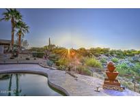 Desert landscaping surrounds the pool with a water feature and palm trees with a view at 16304 E Crystal Ridge Dr, Fountain Hills, AZ 85268