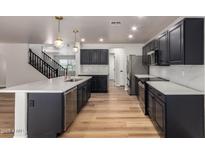 Updated kitchen boasts black cabinets, stainless appliances, light countertops, and an eat-in kitchen island at 2018 E Avenida Del Sol --, Phoenix, AZ 85024