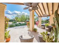 Charming outdoor patio with comfortable seating and a beautiful view of the landscaped garden and blue skies at 22633 N Clubhouse Way, Scottsdale, AZ 85255