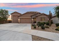 Beautiful single-story home featuring a three-car garage, desert landscaping, and a charming stone facade at 24280 N 164Th Dr, Surprise, AZ 85387