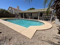 Backyard pool features a rock landscape and covered patio, perfect for outdoor entertaining at 2649 N 85Th Ave, Phoenix, AZ 85037