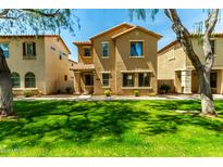 Two-story home with tan stucco, tile roof, well-maintained lawn, and mature trees at 3485 S Seneca Way, Gilbert, AZ 85297