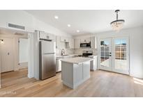 Bright, remodeled kitchen features stainless steel appliances, kitchen island, and stylish backsplash at 3646 N 69Th Ave # 55, Phoenix, AZ 85033