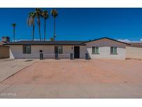 Charming single-story home featuring a fresh white brick exterior and a well-maintained front yard with mature palm trees at 3802 W Mission Ln, Phoenix, AZ 85051