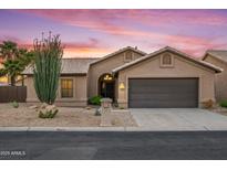 Beautiful single-story home featuring a two-car garage, desert landscaping, and a sunset backdrop at 4020 N 151St Dr, Goodyear, AZ 85395