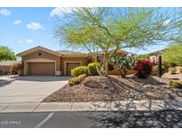 Charming home with a xeriscaped front yard, mature landscaping, and a two-car garage at 41910 N Long Cove Way, Anthem, AZ 85086