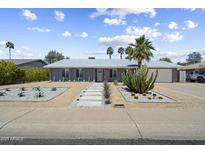 Charming single-story home featuring desert landscaping with a rock lawn, walkway, and large cactus at 4904 E Tierra Buena Ln, Scottsdale, AZ 85254