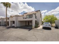 Charming two-story townhome featuring stucco exterior, red tile roof, balcony, and convenient covered parking at 7755 E Thomas Rd # 17, Scottsdale, AZ 85251