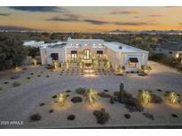 Elegant modern home with desert landscaping, sophisticated lighting, and a private driveway, creating a welcoming ambiance at 8245 E Via Del Sol Dr, Scottsdale, AZ 85255