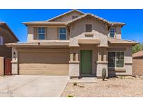 Two-story home featuring desert landscaping, a two car garage, and a covered front entry way at 906 S 242Nd Dr, Buckeye, AZ 85326