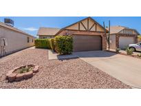 Charming single-story home showcasing a well-manicured yard and a two-car garage at 1247 W Boxelder Cir, Chandler, AZ 85224