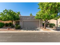 Charming single-story home featuring mature trees and a neutral-toned exterior at 14458 W Zuni Trl, Surprise, AZ 85374