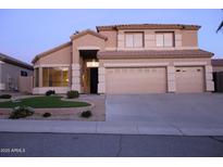 Charming two-story home with a three-car garage, desert landscaping, and a well-manicured front yard at 15229 S 18Th Dr, Phoenix, AZ 85045