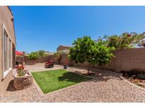 Serene backyard with lush landscaping, artificial turf, gravel, seating, and a well-maintained perimeter fence at 3269 E Ironside Ln, Gilbert, AZ 85298