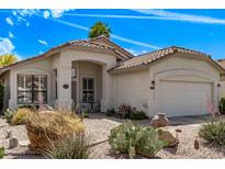 Charming one-story home exterior with a covered entryway, desert landscaping, and two car garage at 4061 W Tonopah Dr, Glendale, AZ 85308