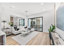 Bright living room boasts sleek modern design, wood floors, sliding doors, and unique mirror display at 4220 N 32Nd St # 39, Phoenix, AZ 85018