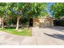 Inviting single-story home featuring a lush front yard and a two-car garage at 4747 N 84Th Way, Scottsdale, AZ 85251