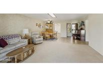 Bright living room featuring a plush couch, recliner, and a dining area with a ceiling fan at 562 S Palo Verde Way, Mesa, AZ 85208