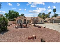 Charming single-story home with desert landscaping and a tile roof under a partly cloudy sky at 63 W Los Arboles Dr, Tempe, AZ 85284
