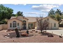 Charming single-story home with desert landscaping featuring cacti and decorative rock accents in the well-maintained front yard at 63 W Los Arboles Dr, Tempe, AZ 85284