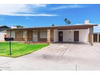 Charming single-story brick home featuring a covered carport and well-maintained front yard at 742 E Garnet Ave, Mesa, AZ 85204