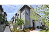 Modern two-story townhome featuring stylish gray siding and professionally landscaped front yard at 7531 E Billings St # 123, Mesa, AZ 85207