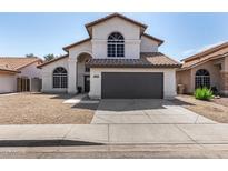 Charming two-story home with an arched entry, tile roof, desert landscaping, and a two car garage at 7869 W Market St, Glendale, AZ 85303