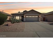 Charming single-story home with desert landscaping and a two-car garage against a vibrant sunset sky at 12425 W Jefferson St, Avondale, AZ 85323