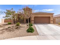 Charming single-story home with a well-manicured front yard and a two-car garage at 19887 N Herbert Ave, Maricopa, AZ 85138