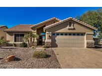 Charming home featuring a paved driveway, desert landscaping, and a two-car garage on a sunny day at 2882 N 155Th Dr, Goodyear, AZ 85395