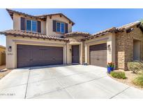 Charming two-story home with a three-car garage, stone accents, and a well-maintained front yard at 3751 E Zachary Dr, Phoenix, AZ 85050