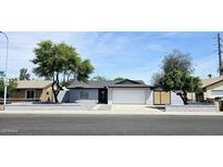 Charming single-story home features a gray exterior, well-manicured yard, and a two-car garage at 5007 N 71St Dr, Glendale, AZ 85303