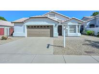 Charming single-story home featuring a well-manicured front yard, two-car garage and desert landscaping at 5226 W Pontiac Dr, Glendale, AZ 85308