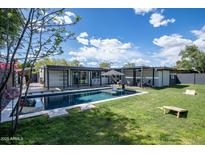 Inviting backyard features a sparkling pool, grassy area, and covered lounge space at 5809 N 10Th Pl, Phoenix, AZ 85014