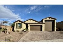 Charming single-story home featuring a brick driveway, neutral stucco, and a two-car garage at 905 S 108Th Ave, Avondale, AZ 85323