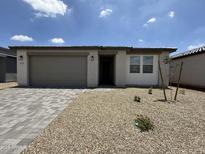 Charming single-story home with desert landscaping and a two-car garage on a sunny day at 9543 W Parkway Dr, Tolleson, AZ 85353