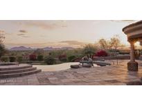 Inviting pool area featuring a spa, desert landscape, and mountain views at sunset at 12711 N 117Th St, Scottsdale, AZ 85259