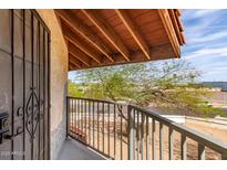 Balcony view with metal railings, desert landscape, and an open-beamed ceiling, offering a serene outdoor space at 16402 N 31St St # 232, Phoenix, AZ 85032