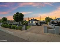 Charming home with a beautifully landscaped front yard and a brick driveway, under a colorful dusk sky at 2316 N Mitchell St, Phoenix, AZ 85006