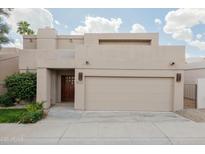 Home exterior featuring a garage, a well-kept yard, and a solid wood front door with square windows at 3033 E Claremont Ave, Phoenix, AZ 85016