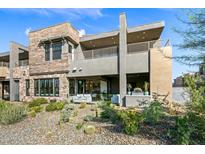Contemporary home featuring a multi-level deck, desert landscaping, and a seamless indoor-outdoor living space at 37200 N Cave Creek Rd # 1122, Scottsdale, AZ 85262