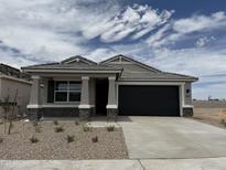 Charming single-story home featuring stone accents, a black garage door, and desert landscaping in the front yard at 46378 W Lander Ln, Maricopa, AZ 85139